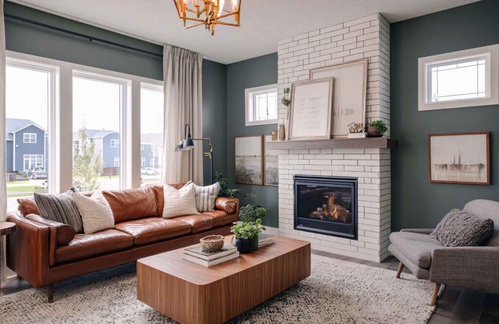 rooted-interior-design-maize-ks-open-vs-closed-floor-plans-cozy-living-room-dark-teal-walls-leather-sofa-fireplace-aligned-interior-design