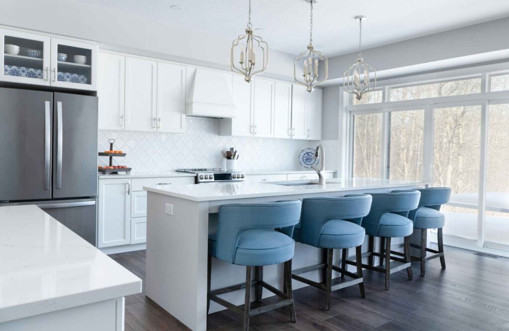 full-service-interior-design-newton-ks-how-designers-source-materials-white-kitchen-with-island-blue-bar-stools-large-windows-aligned-finish-selection