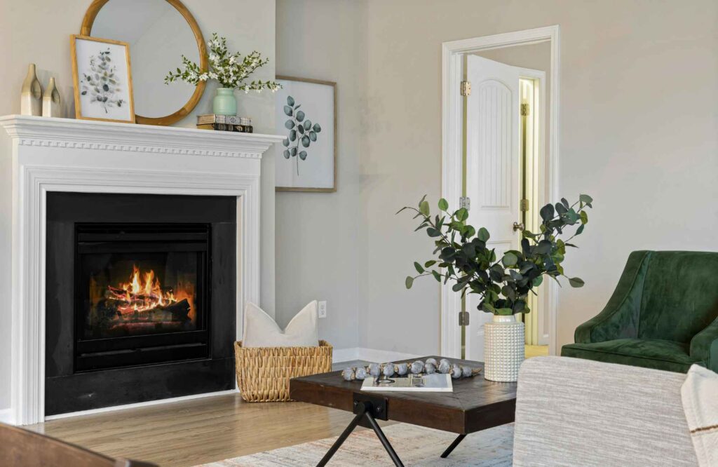 rooted-interior-design-eastborough-ks-renovate-or-build-new-minimalist-living-room-emerald-green-chair-round-mirror-over-fireplace-curated-millwork-design