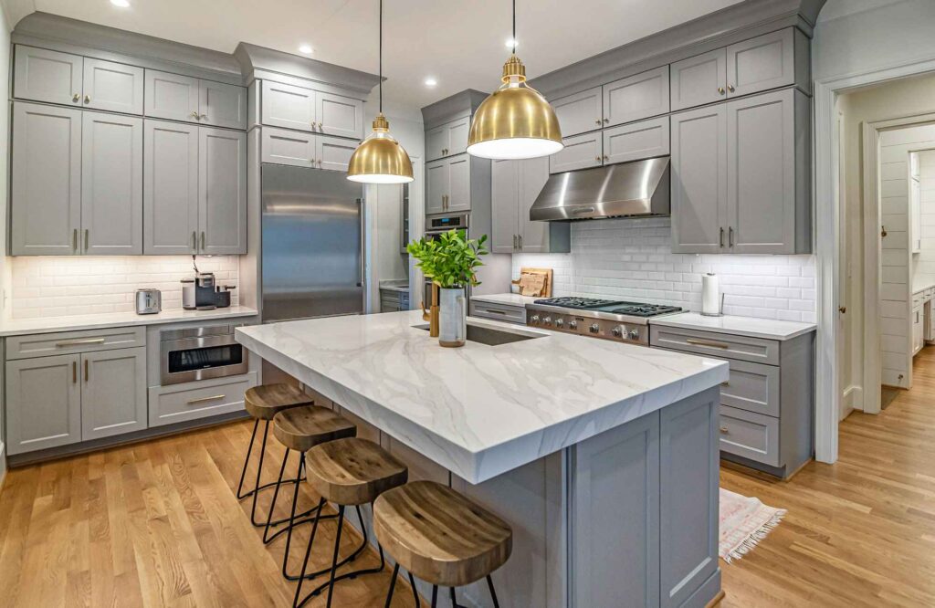rooted-interior-design-wichita-ks-renovate-or-build-new-luxury-kitchen-gray-blue-cabinets-large-island-white-countertops-wood-floors-thoughtful-space-planning
